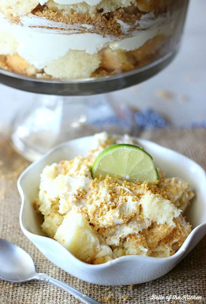 a bowl of cheesecake filling, chopped pound cake, and topped with graham cracker crumbs and sliced lime