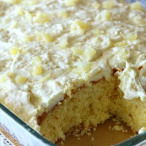 a baking dish full of pineapple cake with a slice taken out