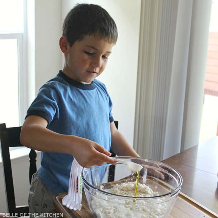 A boy is preparing food in a bowl