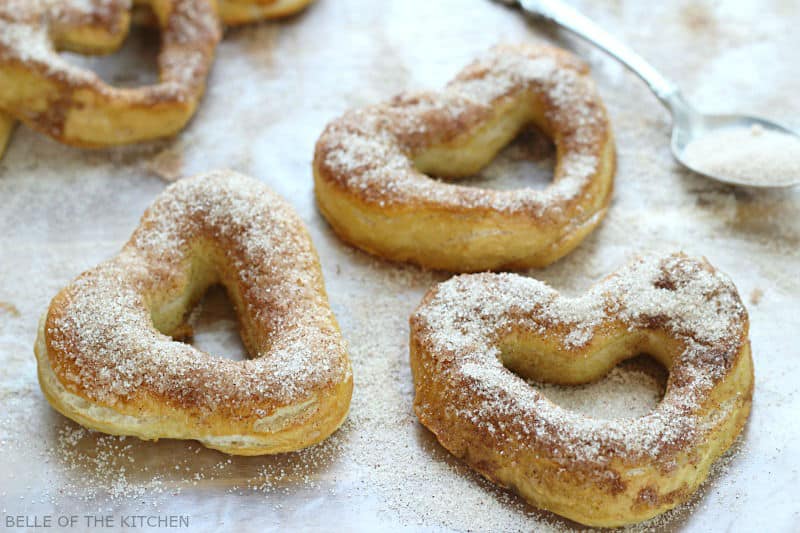 soft pretzels in the shape of hearts on a sheet pan topped with sugar