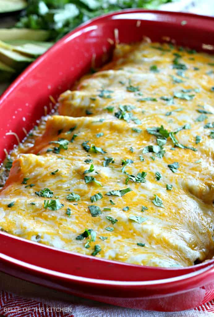 A pan of enchiladas covered in cheese and cilantro 