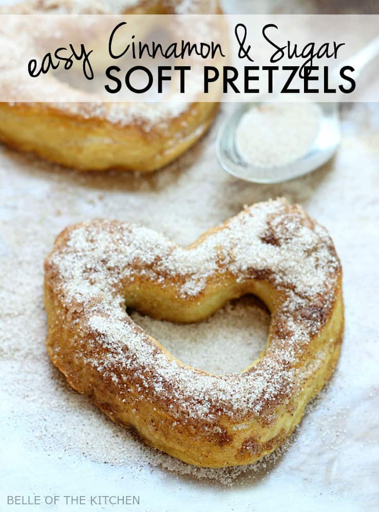 soft pretzels in the shape of hearts on a sheet pan topped with sugar