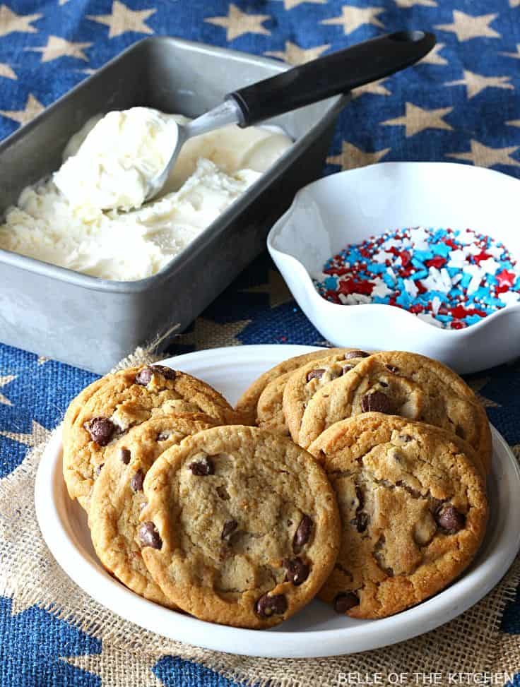 a dish of vanilla ice cream beside a bowl of sprinkles and a plate of chocolate chip cookies