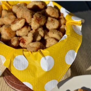 A bowl of chicken nuggets on top of a yellow polka dot napkin