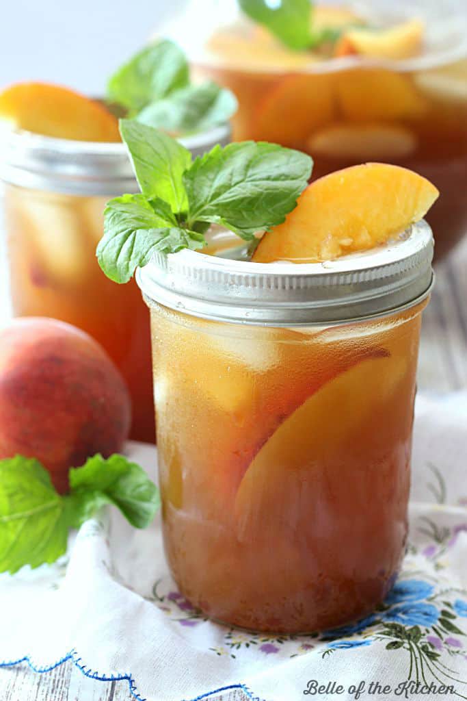 A glass of tea with mint and sliced peaches