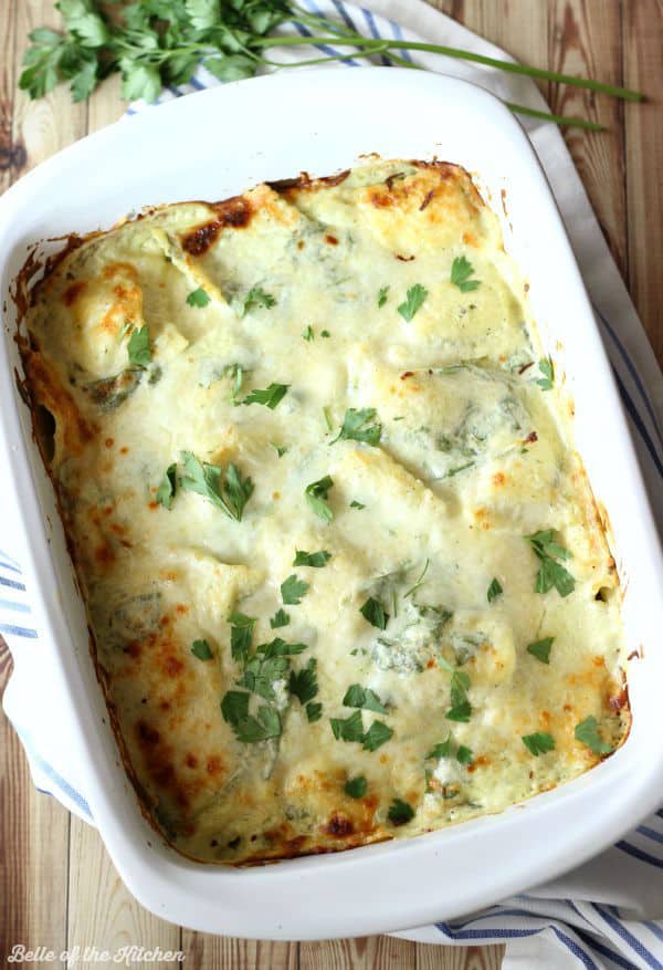 A dish filled with cheesy ravioli topped with parsley