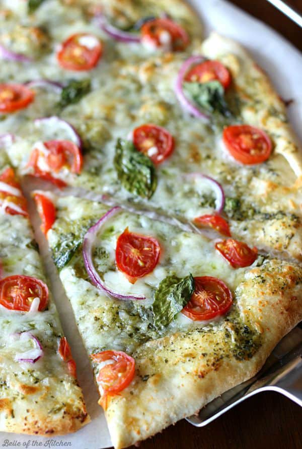 A pizza topped with tomatoes, basil, and red onion