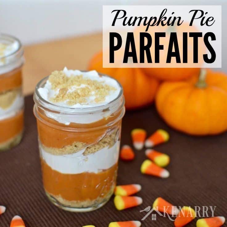 jars with layers of pumpkin, cream cheese, and graham cracker crumbs with mini pumpkins in the background