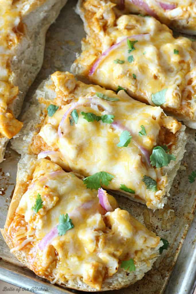 sliced French bread pizza with cheese, red onions, and cilantro on top