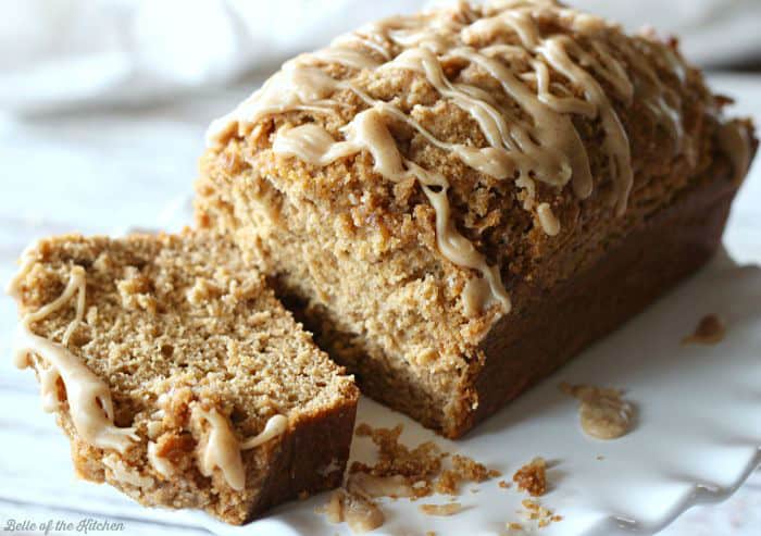 A close up of a loaf of pumpkin bread , sliced, on a white plate