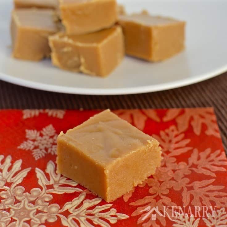 A plate of peanut butter fudge with a slice on a napkin