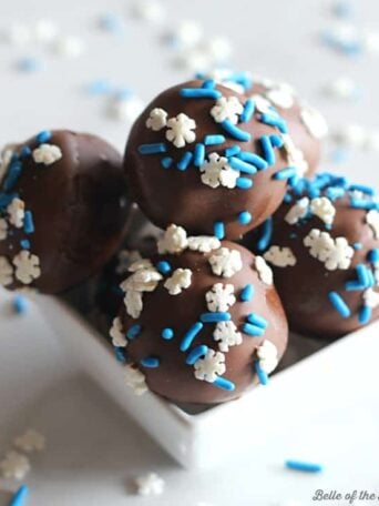 a bowl of chocolate cake balls with blue and white sprinkles