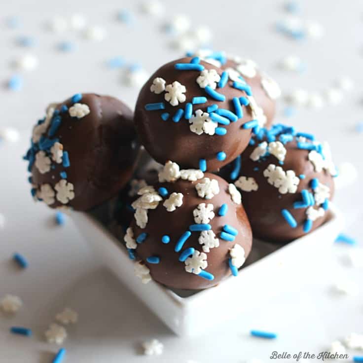 a bowl of chocolate cake balls with blue and white sprinkles