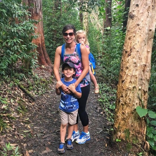 a woman and children hiking in the forest