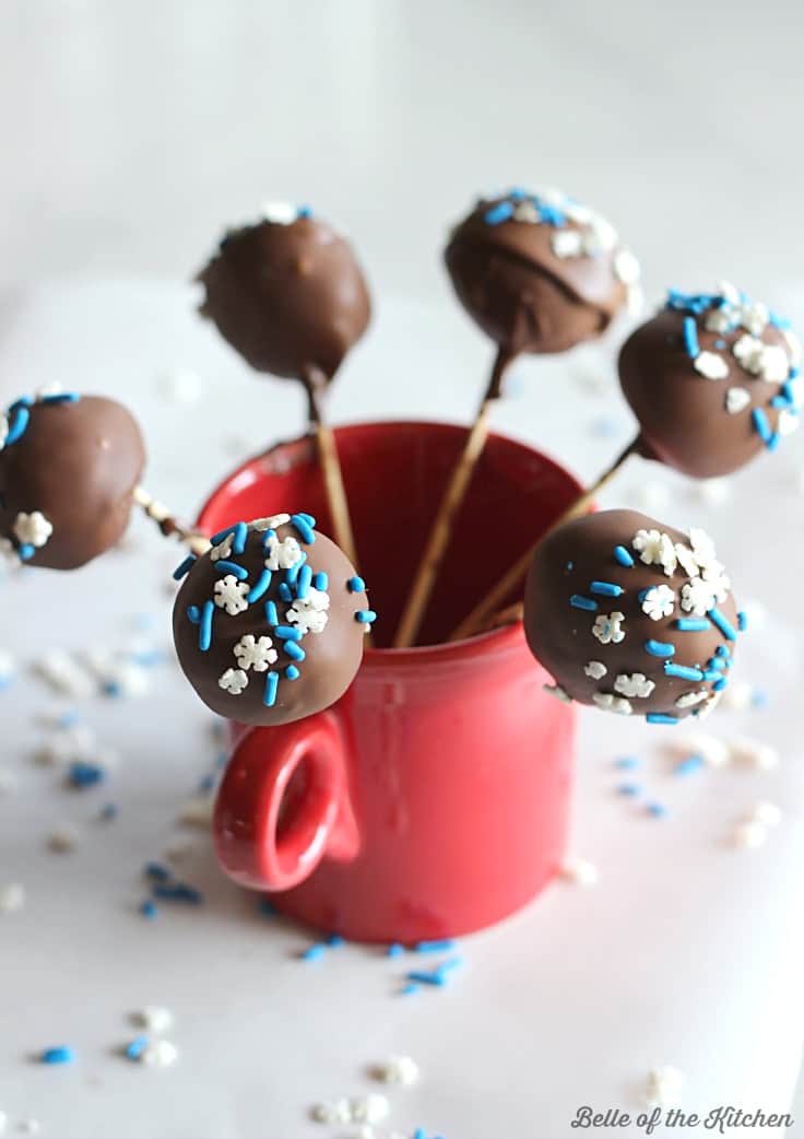 A close up of chocolate cake balls with blue and white sprinkles