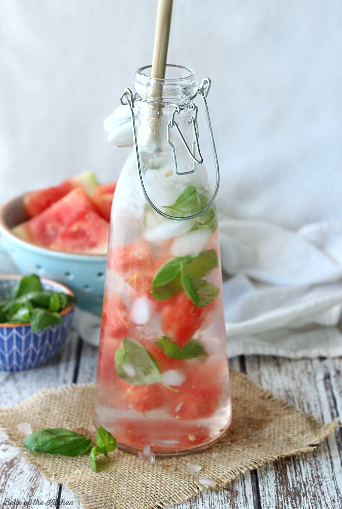 A close up of a carafe filled with watermelon, basil and water