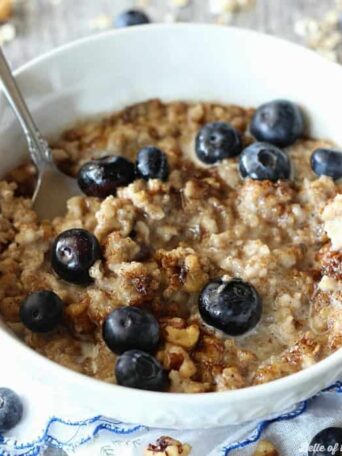 A bowl of oatmeal filled with blueberries