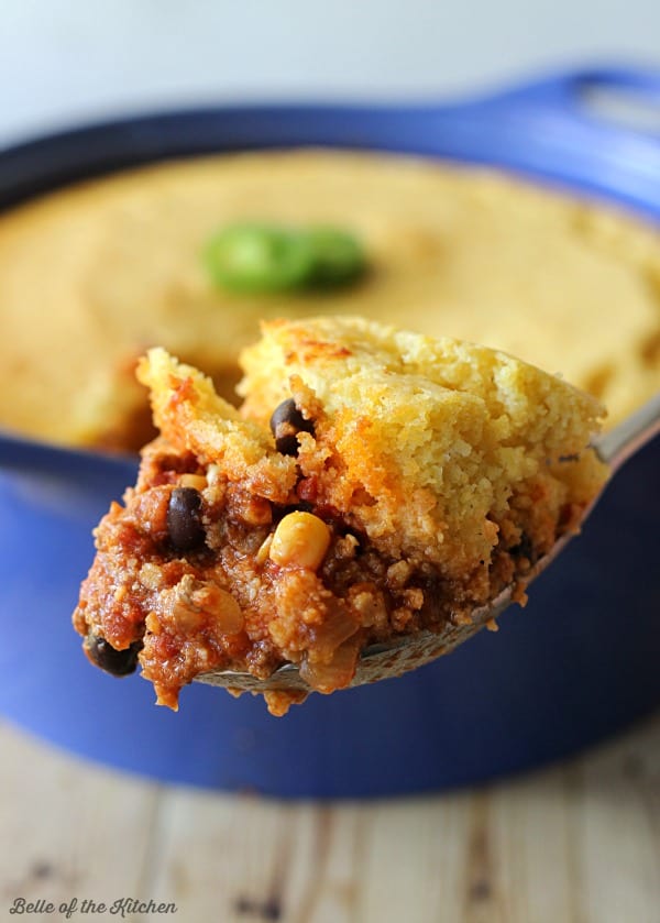 A close up of a spoon of chili Cornbread