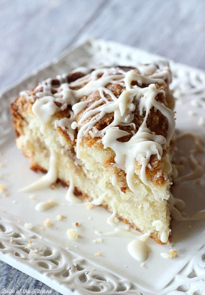 A close up of a piece of coffee cake on a plate, with vanilla glaze
