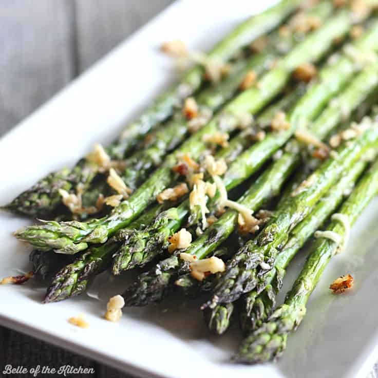 A close up of a plate of food with asparagus and garlic