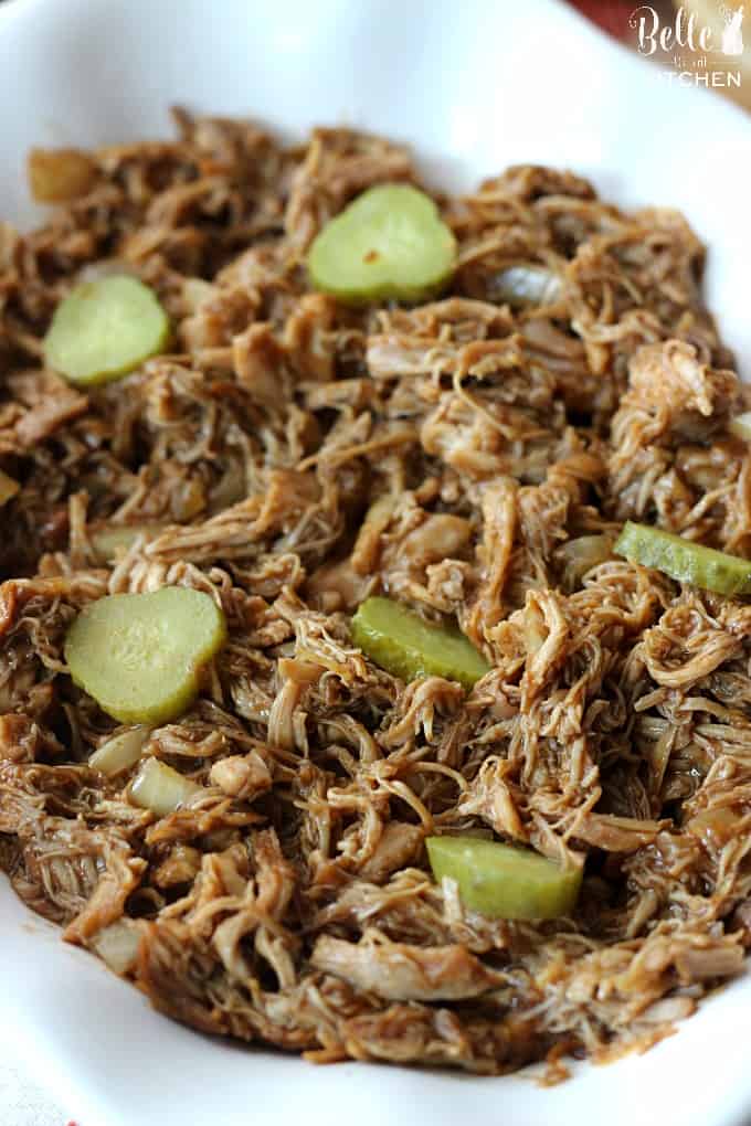 a bowl of pulled bbq chicken with sliced pickles