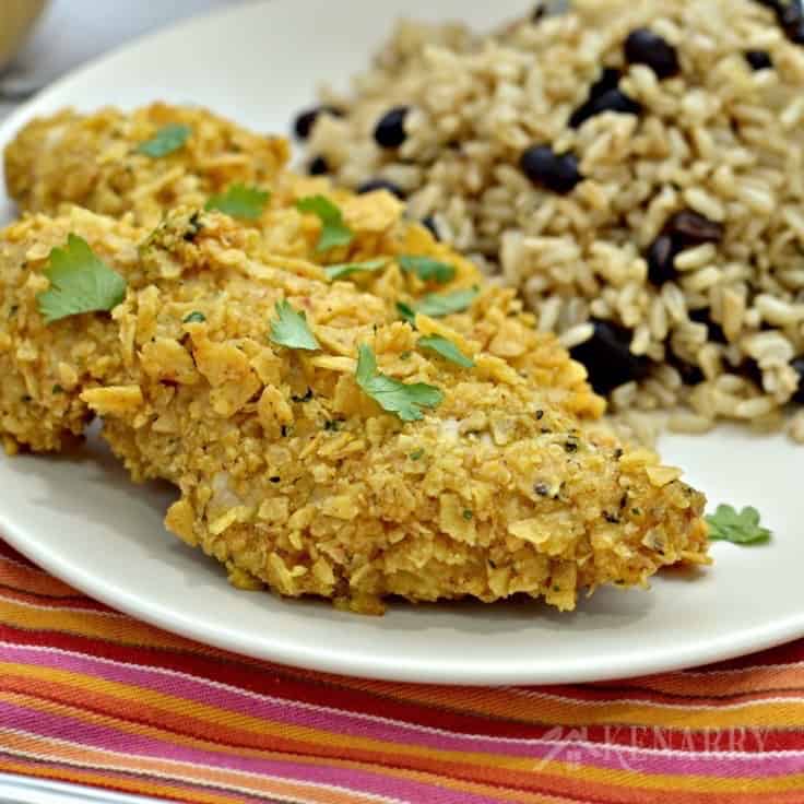 A plate of chicken tenders with rice and beans