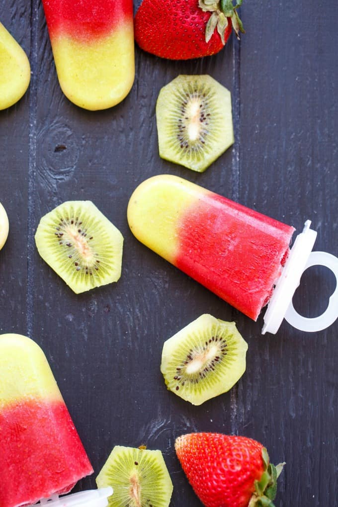 a popsicle on a wooden table with sliced kiwi