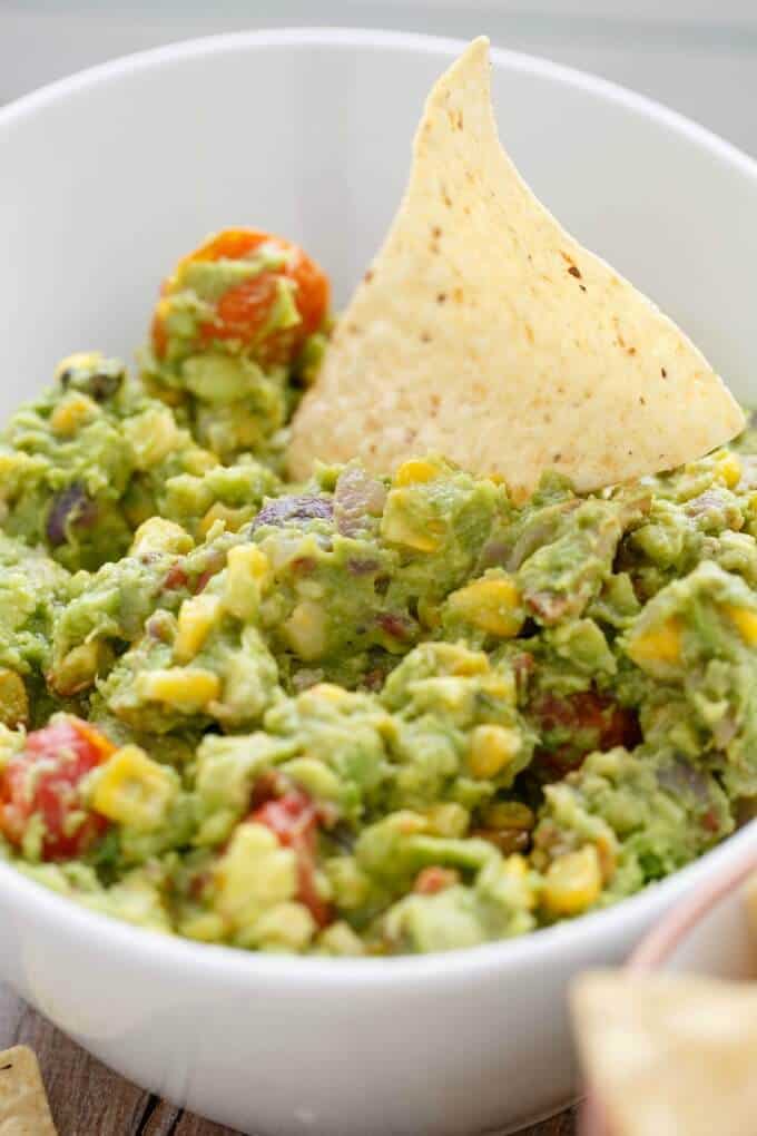 A close up of a bowl of food, with Guacamole and Bacon