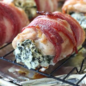A close up chicken wrapped in bacon and filled with spinach