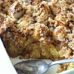 A dish filled with French toast casserole with a spoon