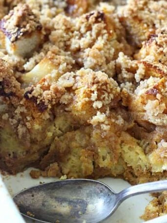 A dish filled with French toast casserole with a spoon