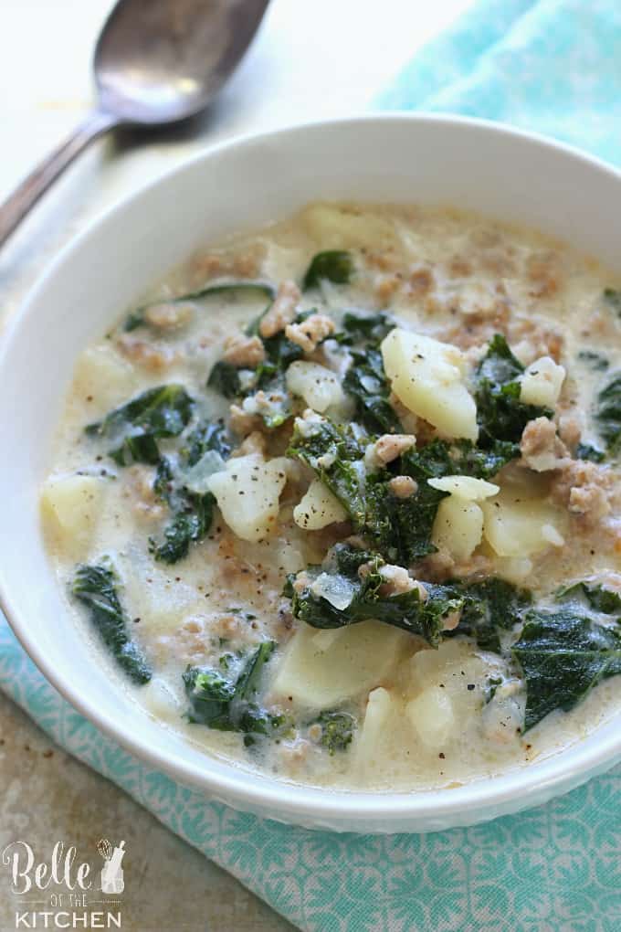 A bowl of soup with potatoes, kale, and sausage