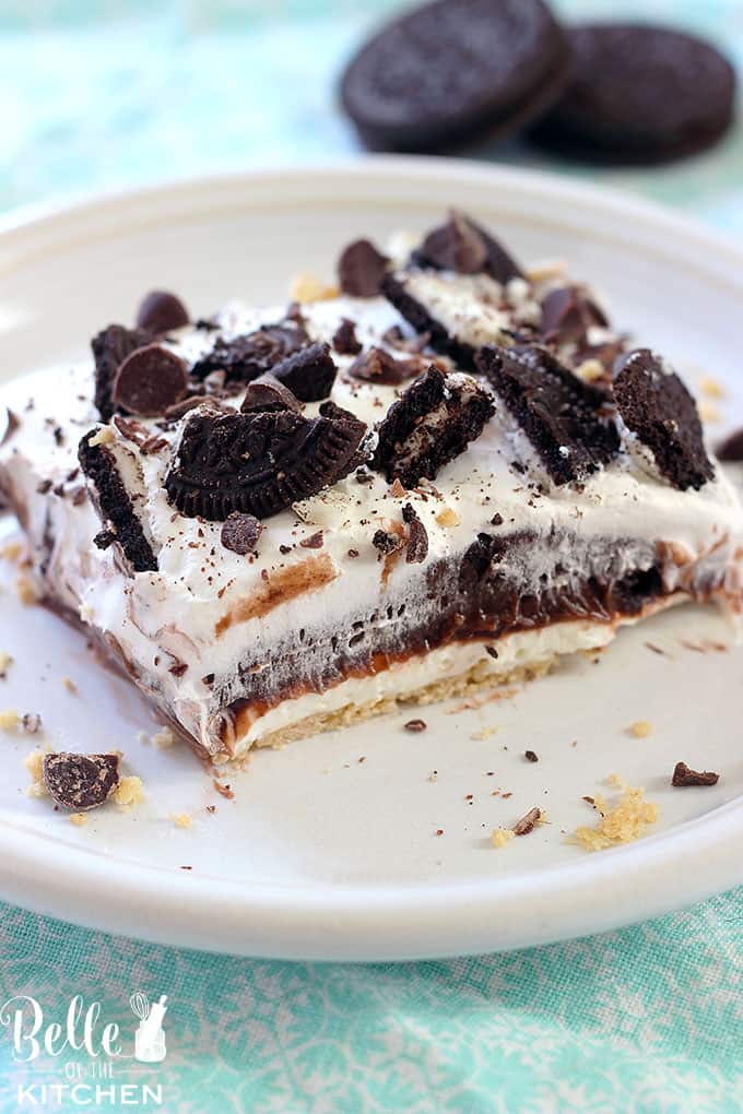 A close up of a piece of cake covered in chocolate and oreos