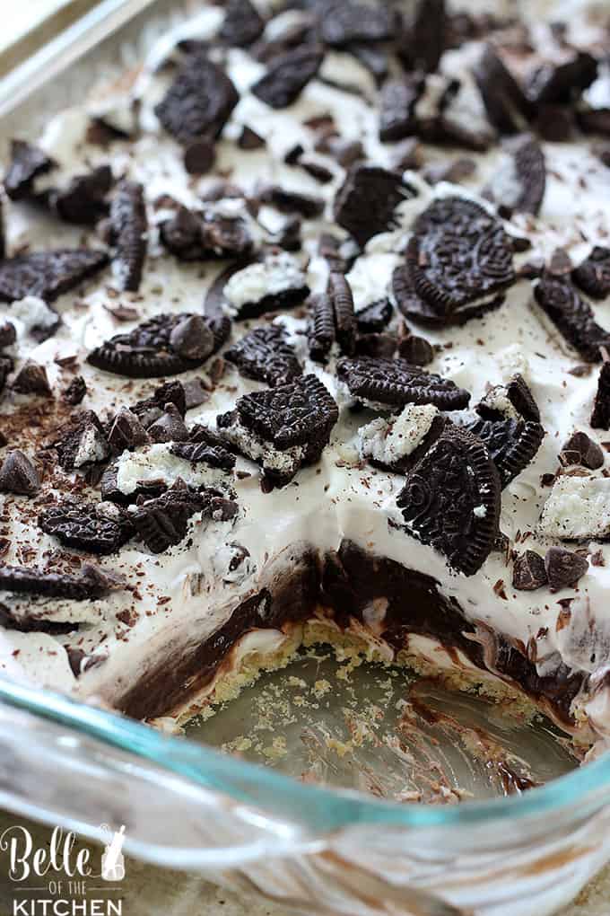 A close up of a piece of cake covered in chocolate and oreos 