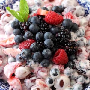 A closeup of fruit salad with greek yogurt in a blue and white bowl