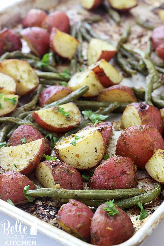 A close up of Pesto and Potatoes with green beans on a sheet pan