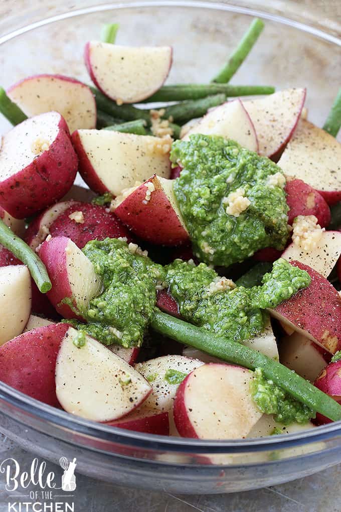 A bowl filled with food, with red Potatoes, Pesto, garlic, and green beans