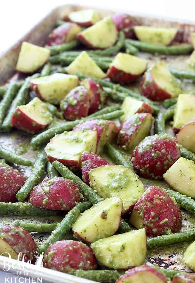 A close up of Pesto and Potatoes with green beans on a sheet pan