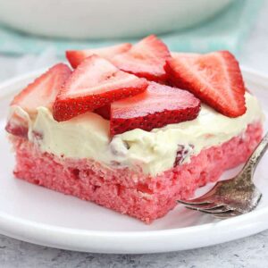 A close up of a slice of strawberry cake on a plate
