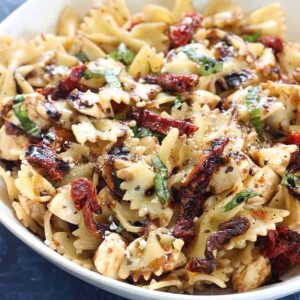 a dish filled with pasta salad and sun dried tomatoes