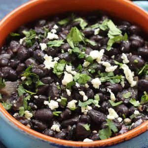 A bowl filled with black beans and cotija