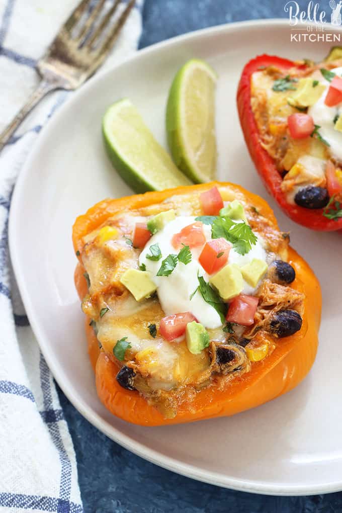 A plate of sliced peppers filled with chicken enchilada filling and sliced limes on the side