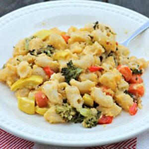 A plate of macaroni and cheese with veggies