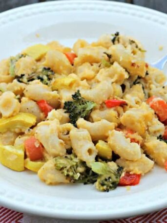 A plate of macaroni and cheese with veggies