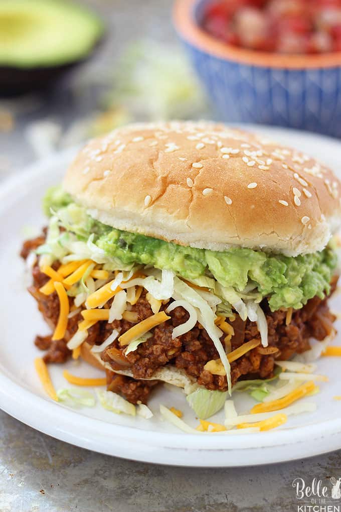 Un sloppy Joe sándwich en un plato con queso y lechuga