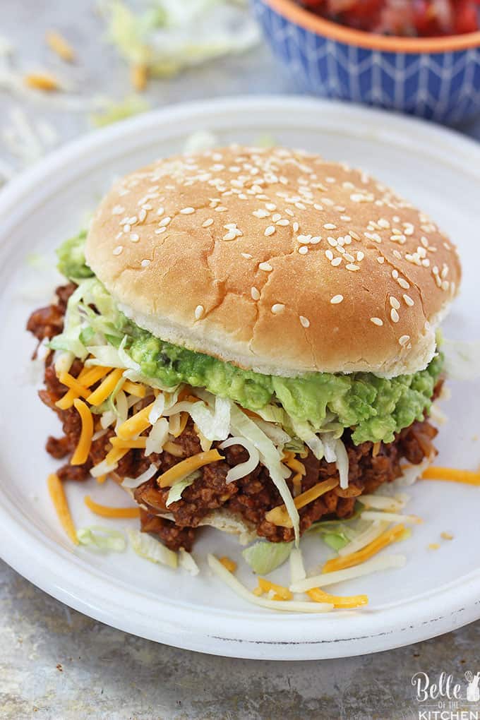 A sloppy Joe sandwich on a plate with cheese and lettuce