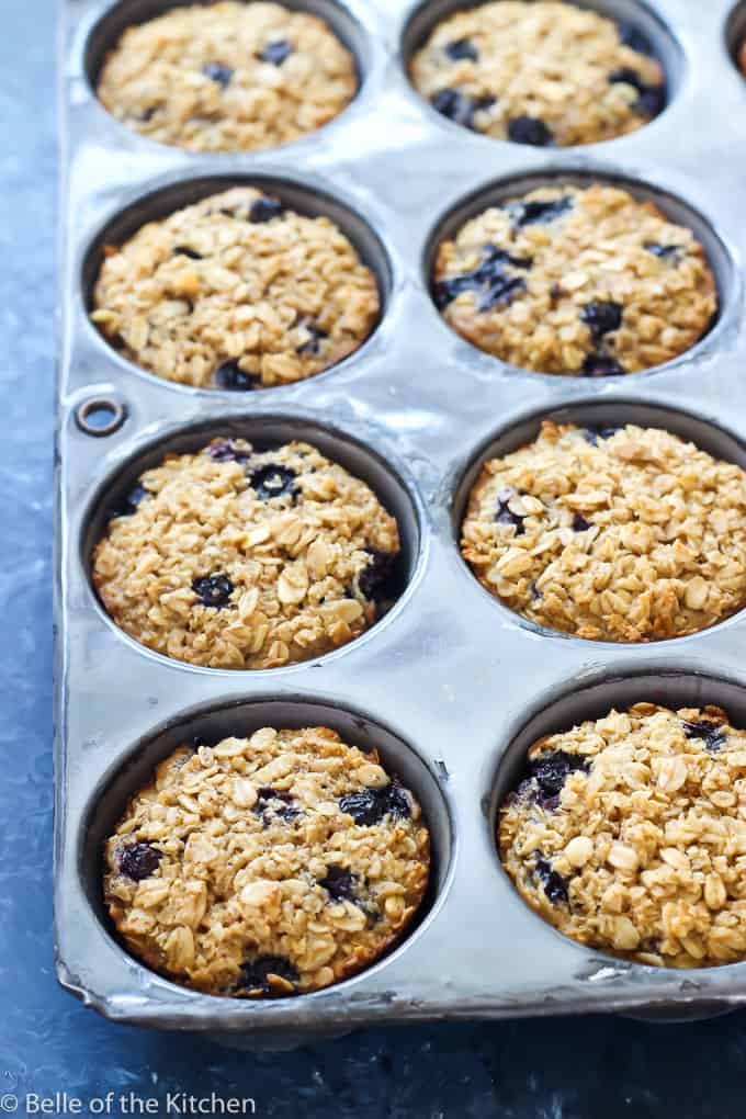 a muffin tin filled with baked blueberry oatmeal cups