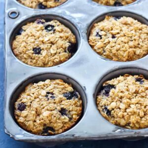 a muffin tin filled with baked blueberry oatmeal cups