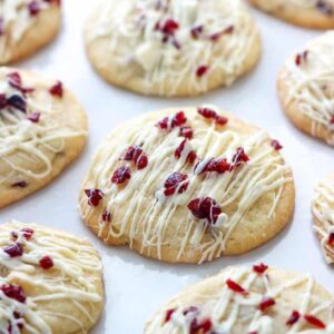 cookies with cranberries and icing on parchment paper
