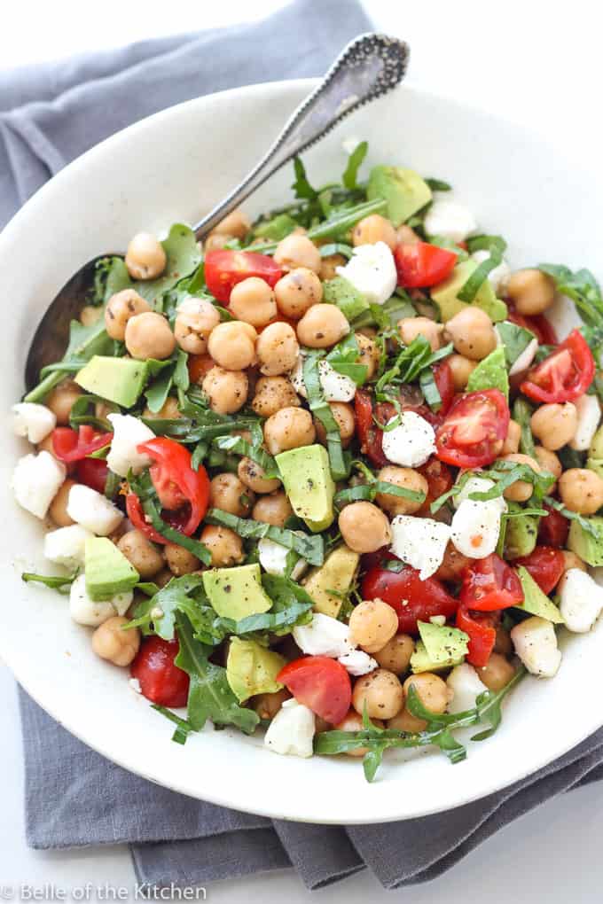 A plate full of salad with chickpeas and avocado 